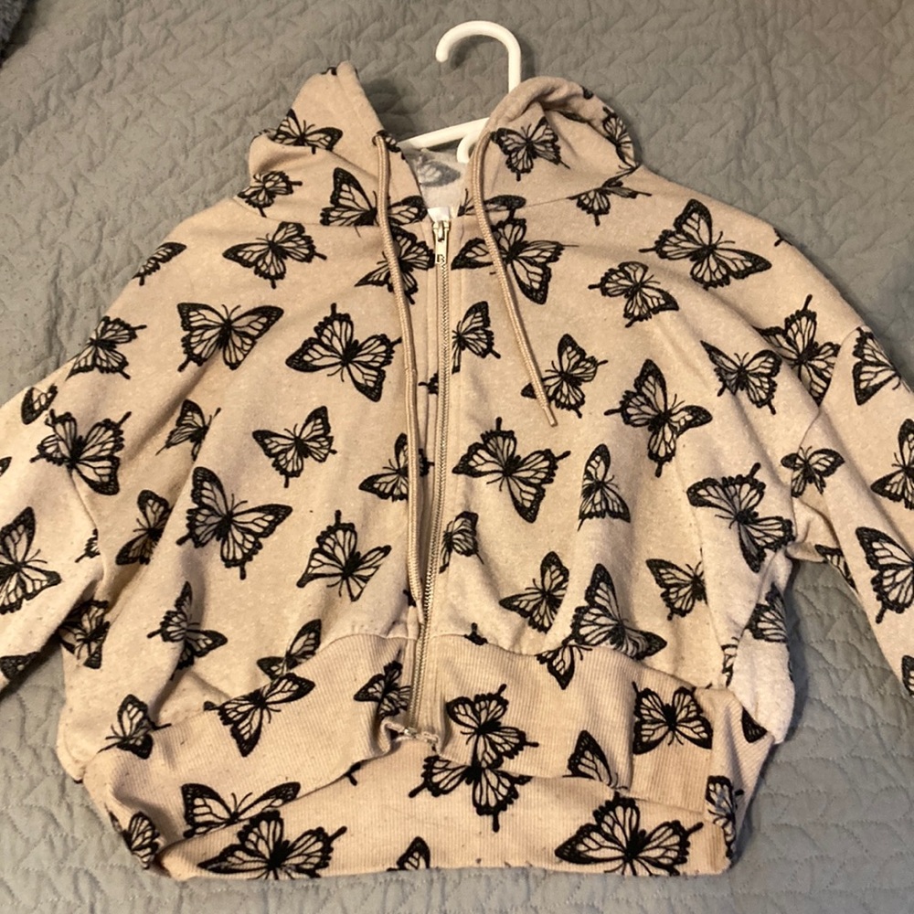 Tan and black sweater has butterflies on it
